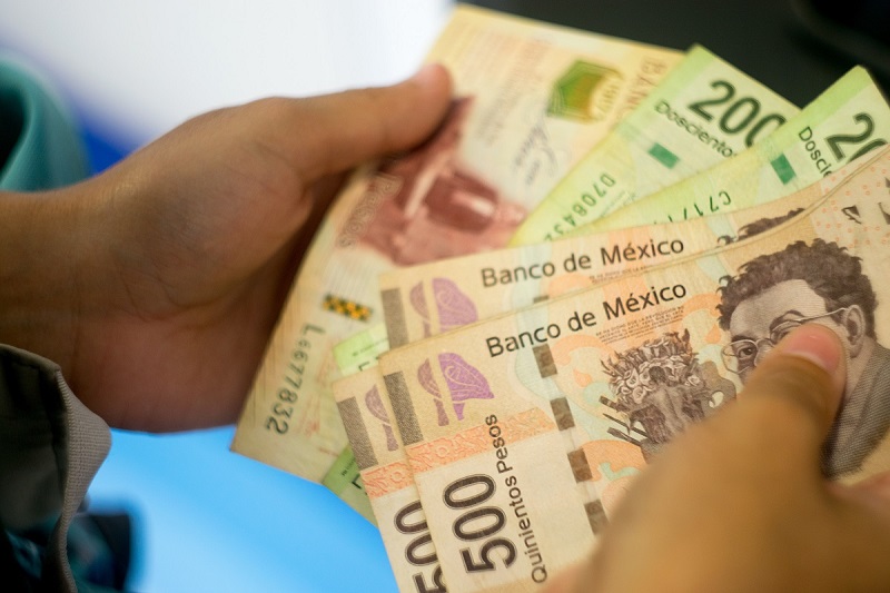 Pessoa contando pesos mexicanos