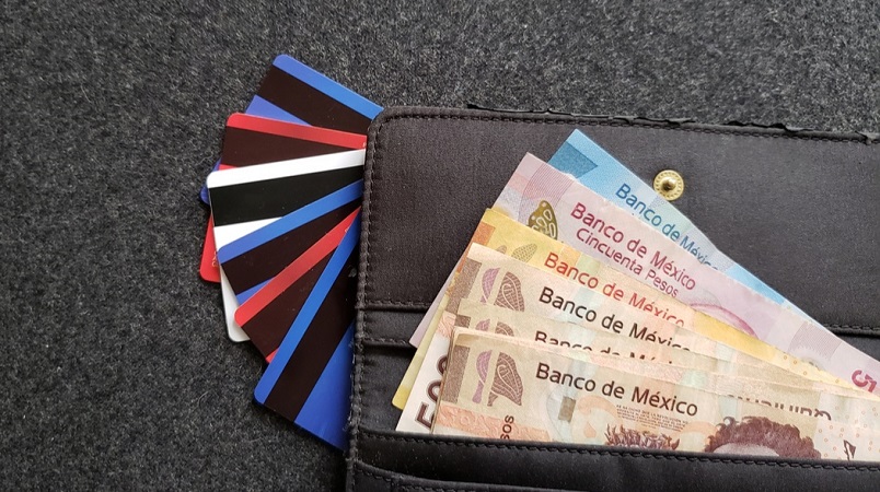Carteira com pesos mexicanos e cartões de crédito