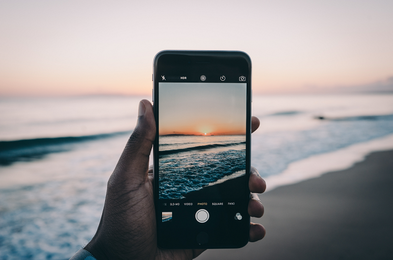 Usando o celular para fotografar praia